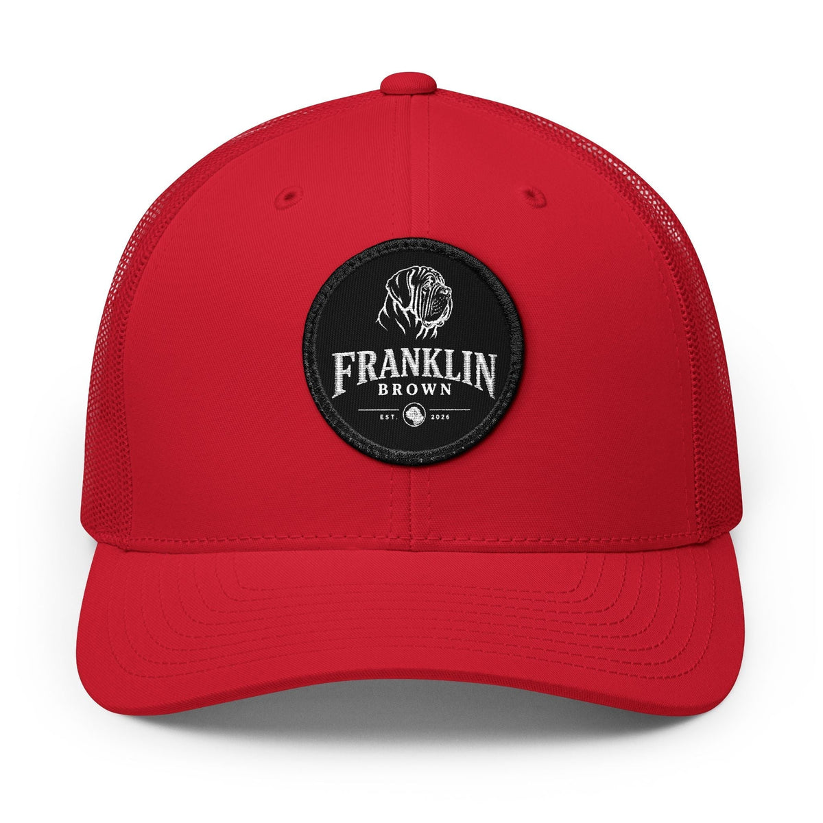 Red trucker cap with mesh back and black circular patch featuring a lion logo and 'Franklin Brown' text, adjustable snapback closure