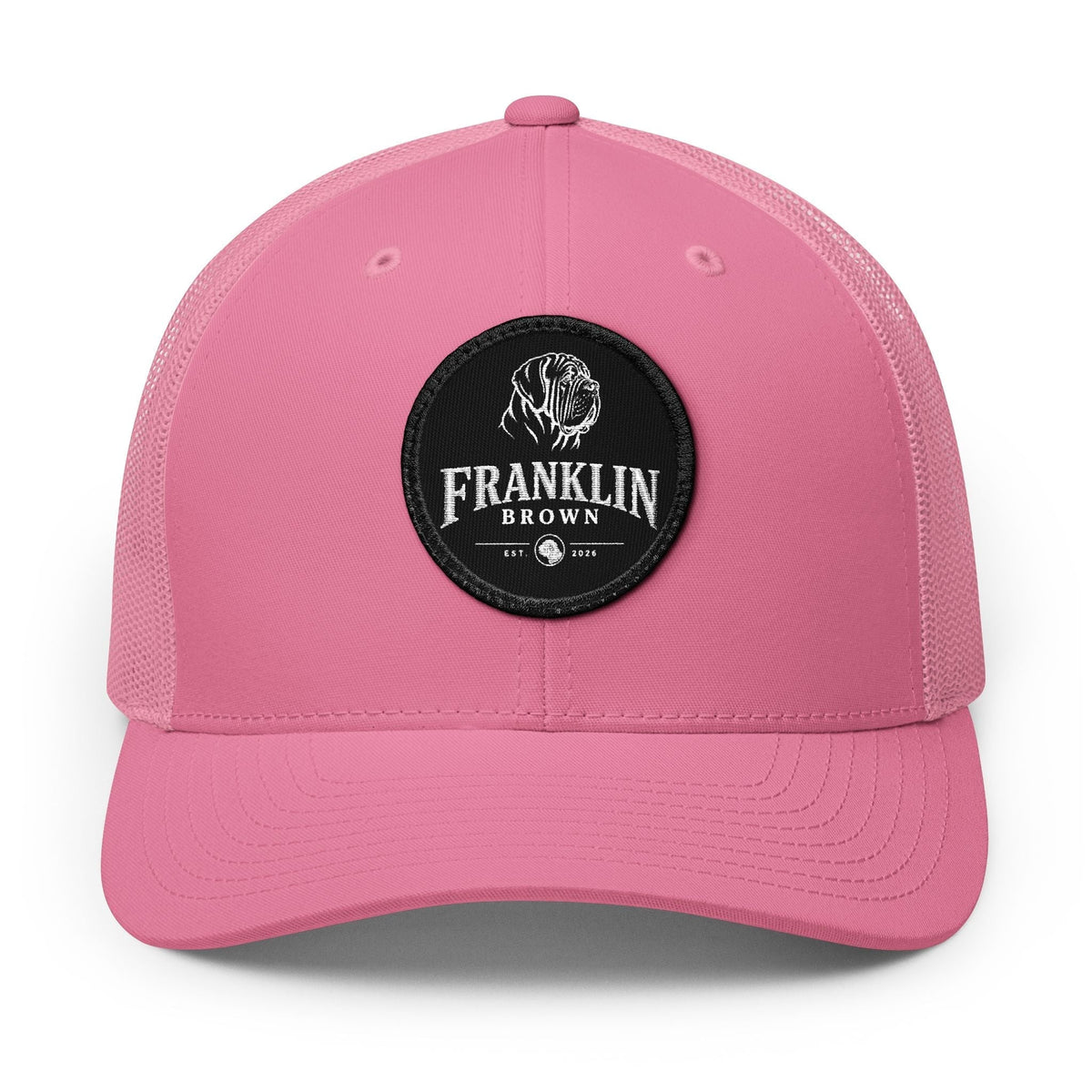 Pink trucker cap with mesh back and black circular patch featuring a dog logo and 'Franklin Brown' text, adjustable snapback closure