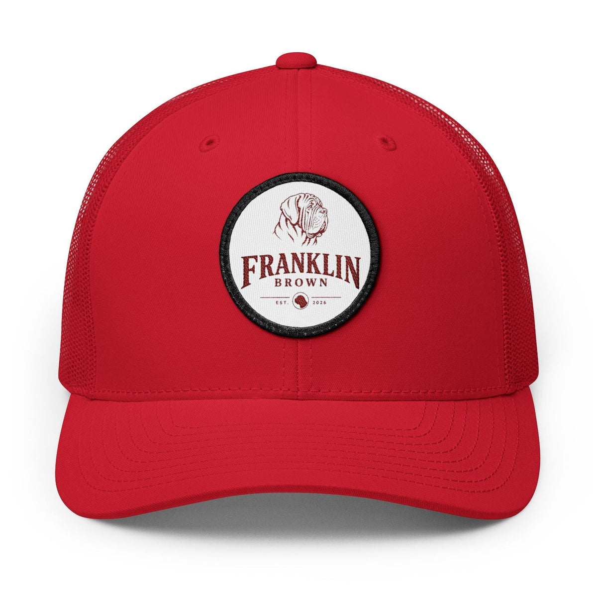 Red trucker cap with mesh back and adjustable snap closure, featuring a circular patch with a dog illustration and 'Franklin Brown' text